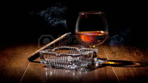 35868425-sigaro-sul-portacenere-e-cognac-su-un-tavolo-di-legno